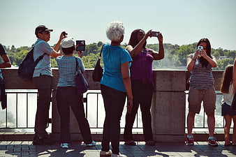 Tourists Taking Photos at Scenic Waterfall Viewpoint