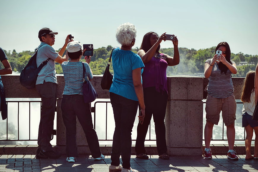 Tourists Taking Photos at Scenic Waterfall Viewpoint