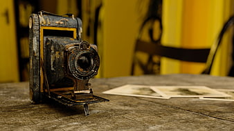 Vintage Rusty Camera on Wooden Table with Old Photographs