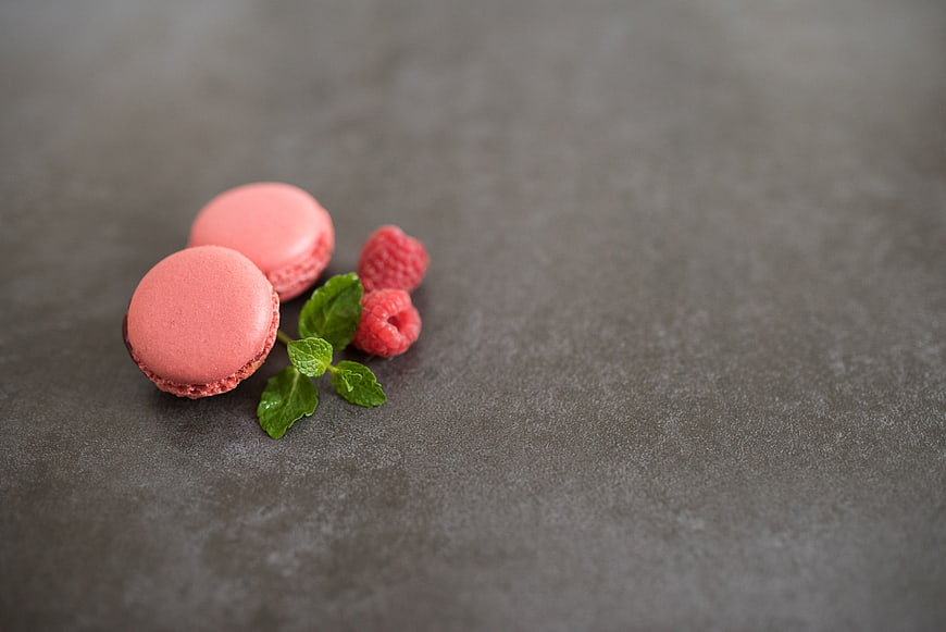 Pink Macarons with Raspberries and Mint on Dark Slate