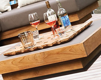 Wooden tray with wine glasses and bottles on outdoor table