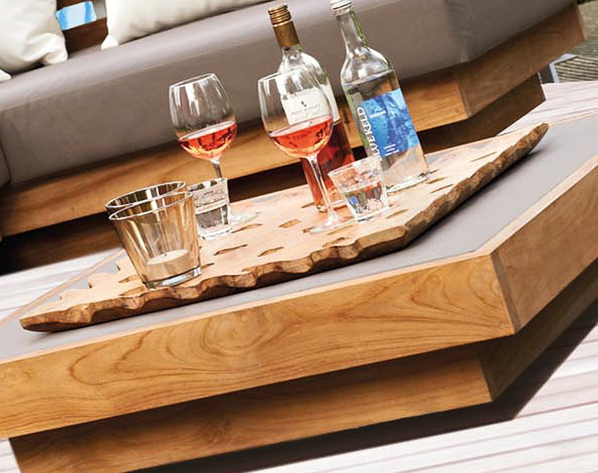 Wooden tray with wine glasses and bottles on outdoor table