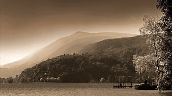 Sepia-toned lake landscape with mountains and dock