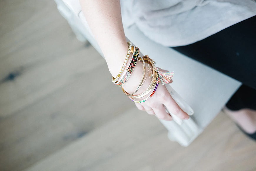 Close-up of woman's wrist with stacked gold bangles