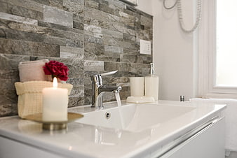 Modern Bathroom Sink With Candle, Towels, And Stone Wall