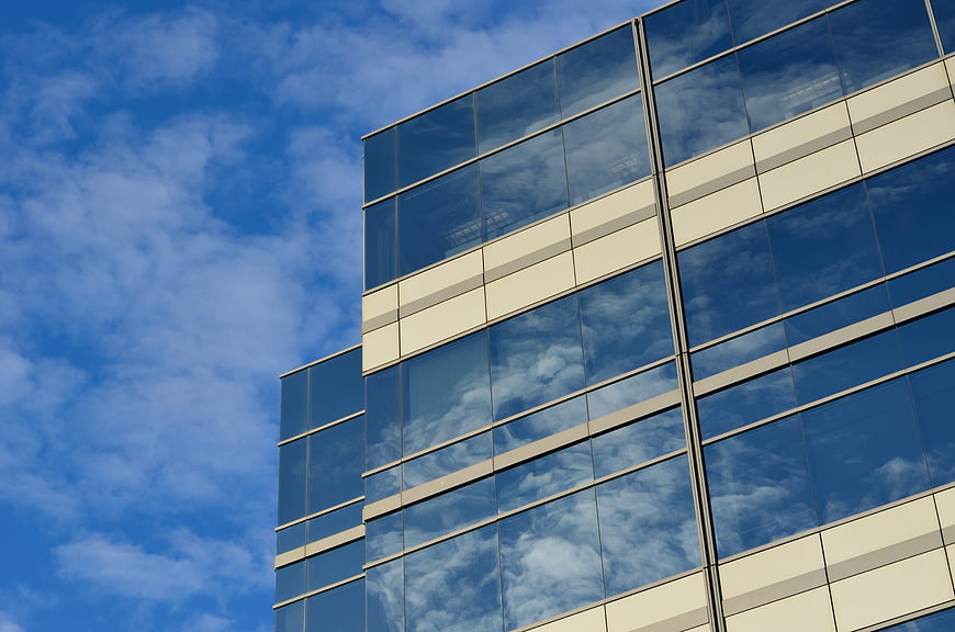 Modern Glass Office Building with Cloud Reflections