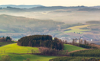 Misty rolling hills and forested landscape in the Sauerland region