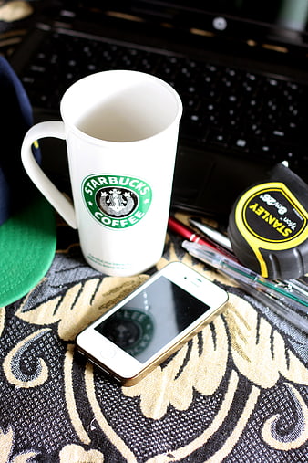 Starbucks mug, smartphone, and tools on patterned fabric