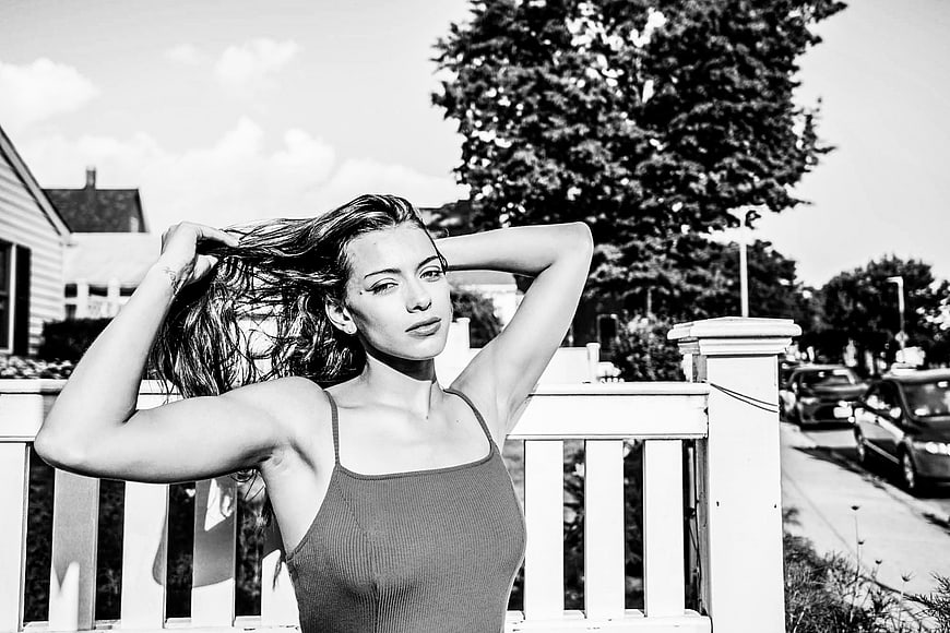 Black and white portrait of woman posing on porch