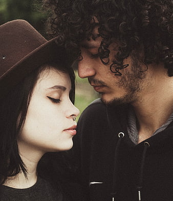 Intimate Close-Up of Romantic Couple with Curly Hair and Hat
