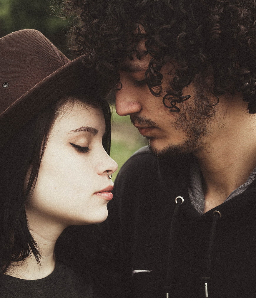 Intimate Close-Up of Romantic Couple with Curly Hair and Hat