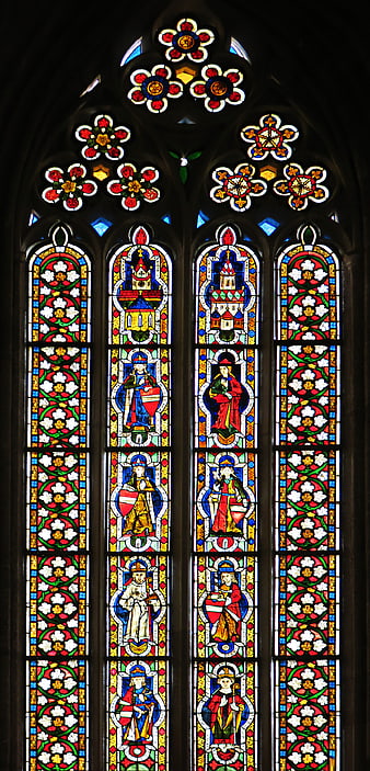 Gothic stained glass window with saints and floral patterns