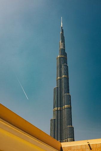 Burj Khalifa skyscraper against blue sky with contrail