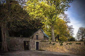 Rustic brick building with blue tarp roof in autumn park