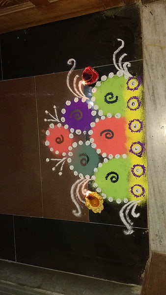 Colorful Rangoli Art with Oil Lamps on Floor