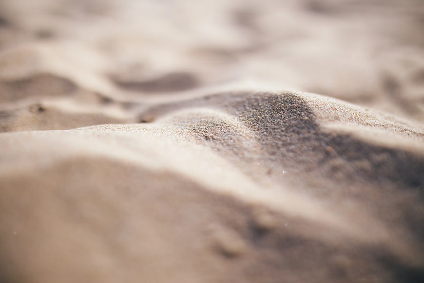 Close-up of textured gray sand ripples with shallow depth of field