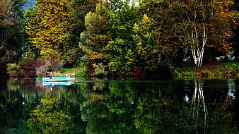 Blue Rowboat on Calm Lake with Autumn Forest Reflections