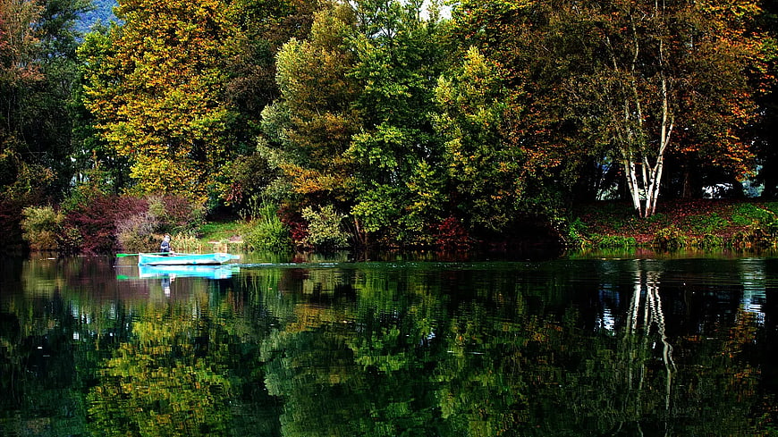 Blue Rowboat on Calm Lake with Autumn Forest Reflections