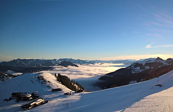 Panoramic winter mountain landscape with sea of clouds and ski resort