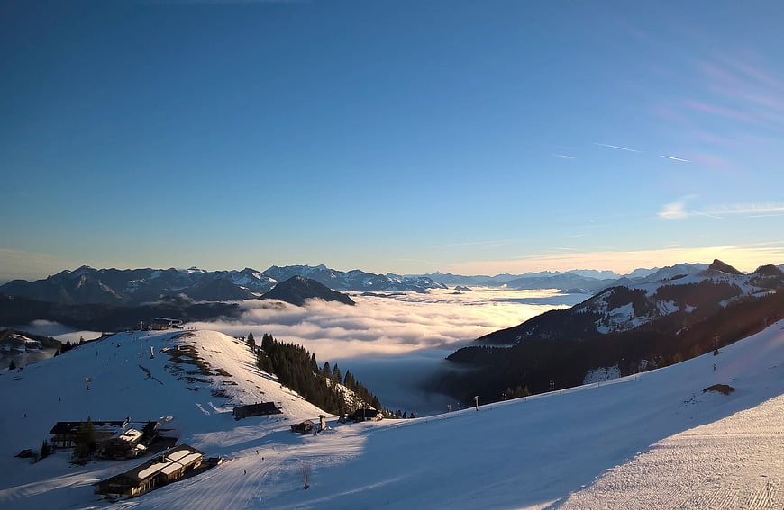 Panoramic winter mountain landscape with sea of clouds and ski resort