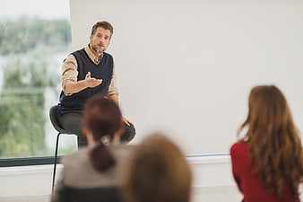 Male Presenter Speaking to Audience in Modern Office