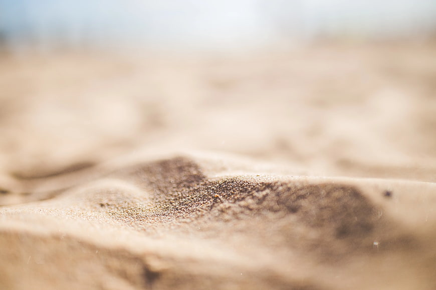 Close-up of textured brown sand grains on a beach