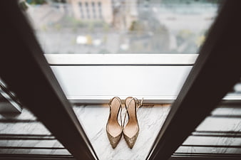 Gold glitter high heels on marble windowsill