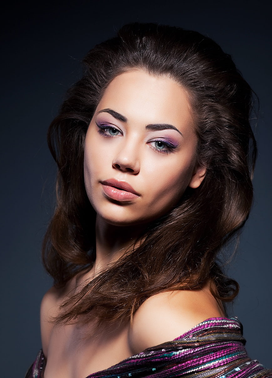 Portrait of a woman with purple eyeshadow and wavy hair