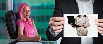 Businessman showing photo of woman to pink-haired colleague