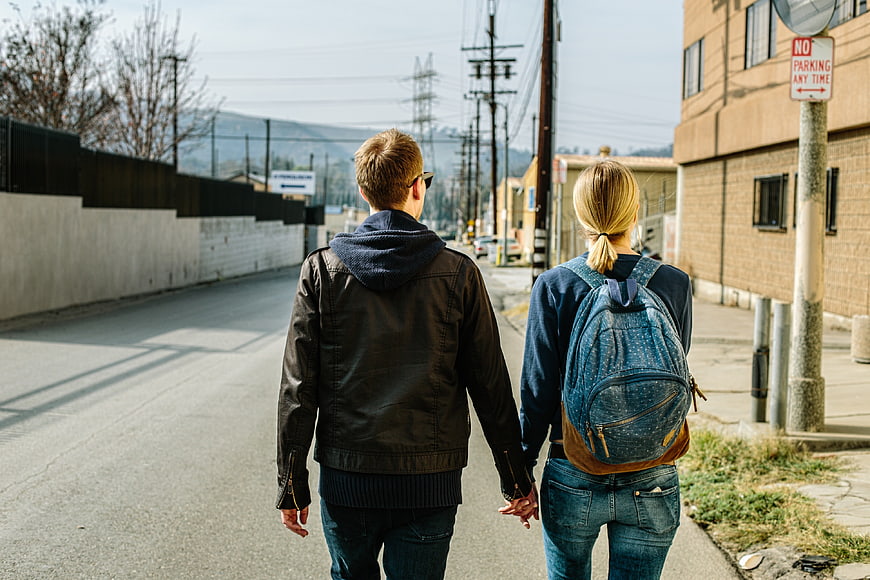 Couple Walking Away Holding Hands on Urban Street