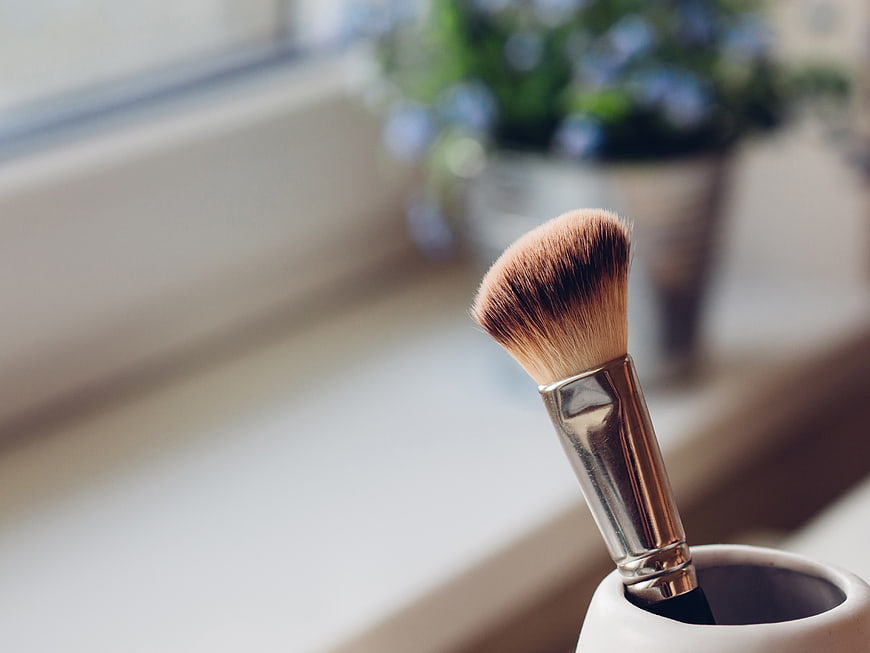 Close-up of makeup brush in white holder