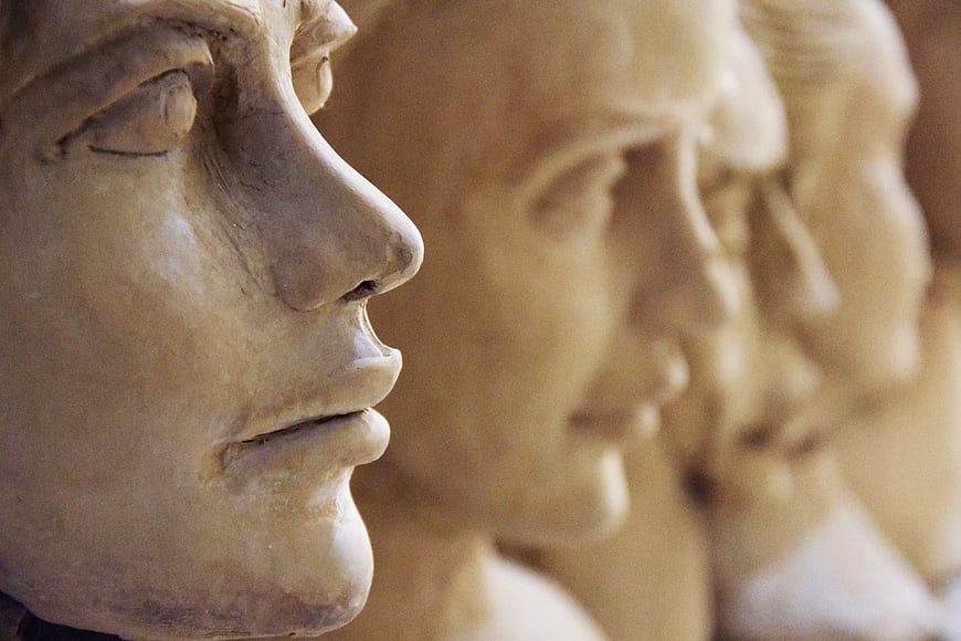 Close-up of ancient stone busts in profile