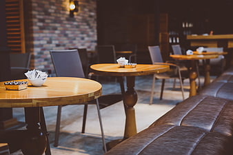 Empty wooden tables and leather sofa in a cozy cafe interior