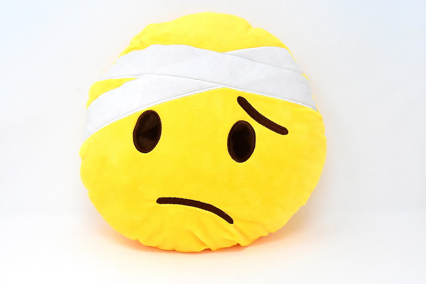 Sad Bandaged Emoji Plush Pillow on White Background