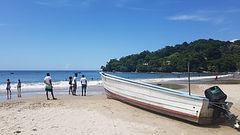 White Fishing Boat on Sandy Tropical Beach with People