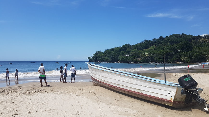 White Fishing Boat on Sandy Tropical Beach with People