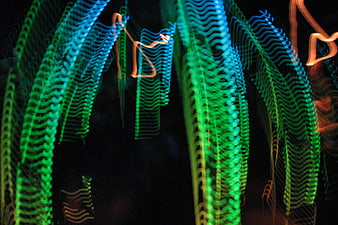Abstract blue and green light trails on black background