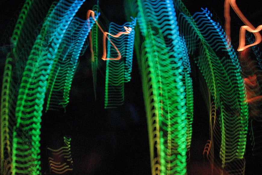 Abstract blue and green light trails on black background