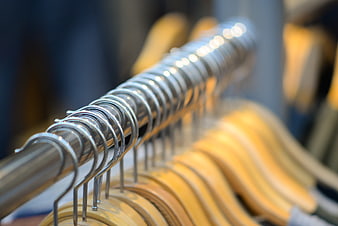 Close-up of wooden hangers on a metal clothing rack