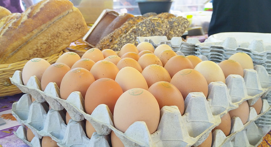 Fresh brown eggs in cardboard carton with bread