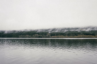 Serene Lake Landscape with Foggy Forest and Mountains