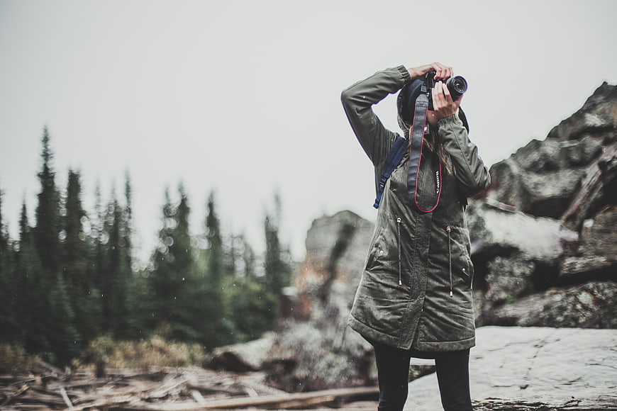Woman Photographer Taking Photo in Snowy Mountain Landscape