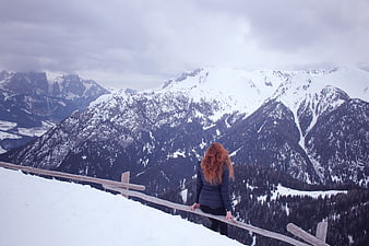 Woman with Red Hair Looking at Snowy Mountain Landscape