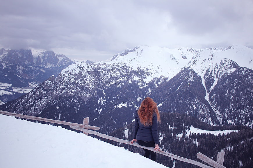 Woman with Red Hair Looking at Snowy Mountain Landscape