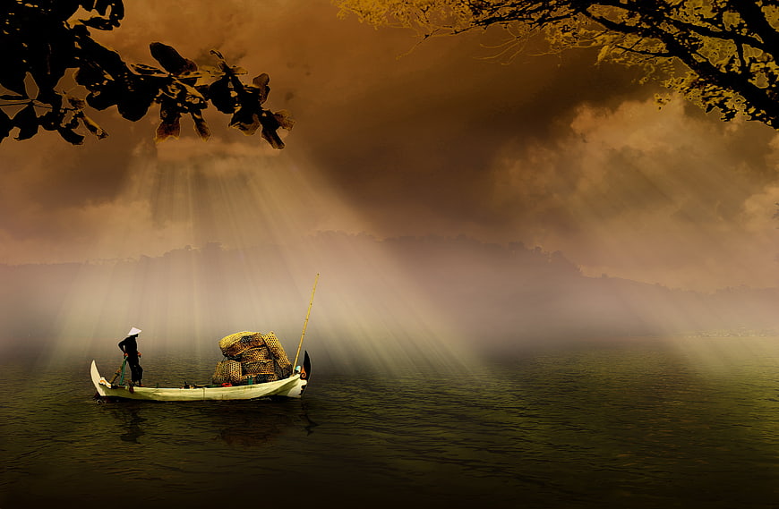 Silhouette of Fisherman in Boat with Dramatic Sunbeams