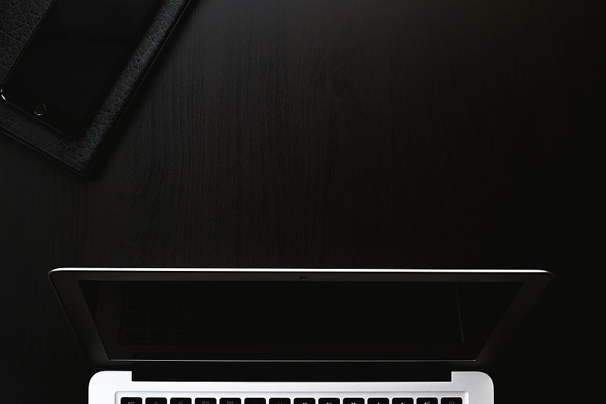 Minimalist Black Workspace with Laptop and Smartphone