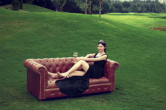 Elegant Woman in Black Dress on Leather Sofa in Park