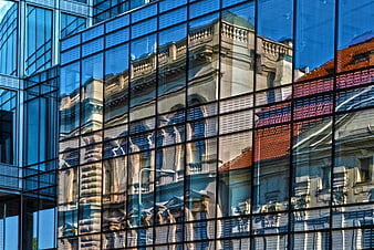 Modern glass building reflecting historic architecture