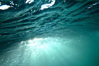 Underwater Sunbeams Piercing Through Turquoise Ocean Water