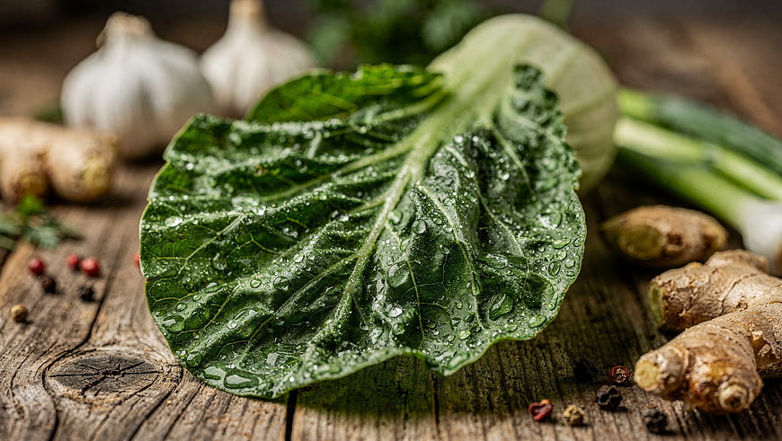 Fresh Green Leaf with Garlic and Ginger on Wood